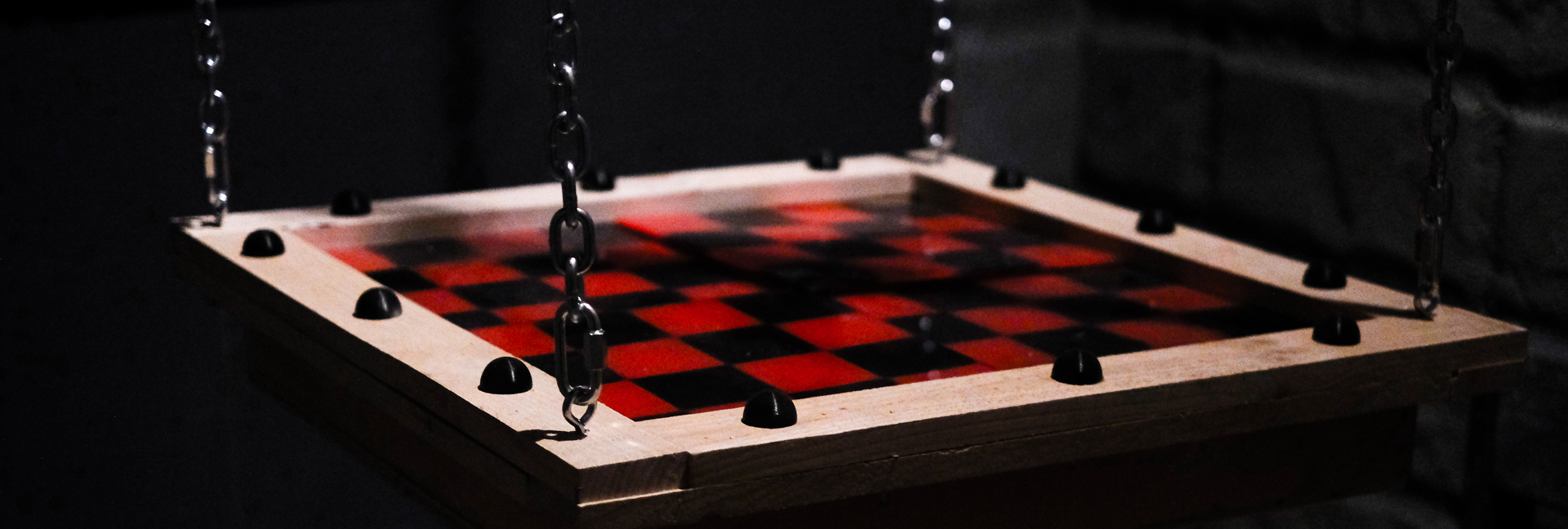 Here's an alt tag for the image: Red and black checkerboard hanging game.